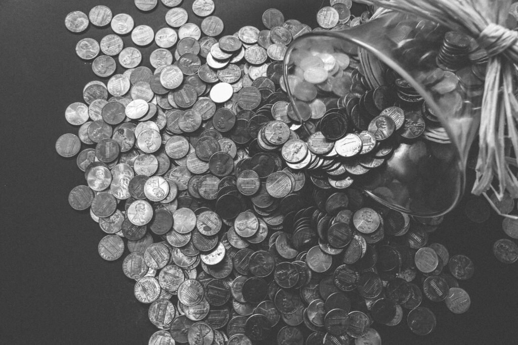 pexels-photo-259209-259209 Monochrome image of coins spilling from a glass jar, symbolizing wealth and savings.